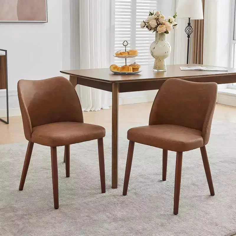 Sedia da pranzo rivestita in pelle con gambe in legno e schienale a orecchioni